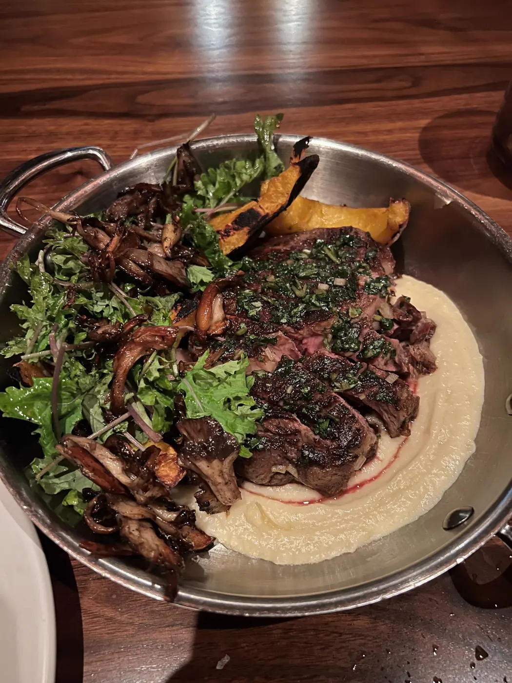 Pan of sliced steak with mushrooms and greens
