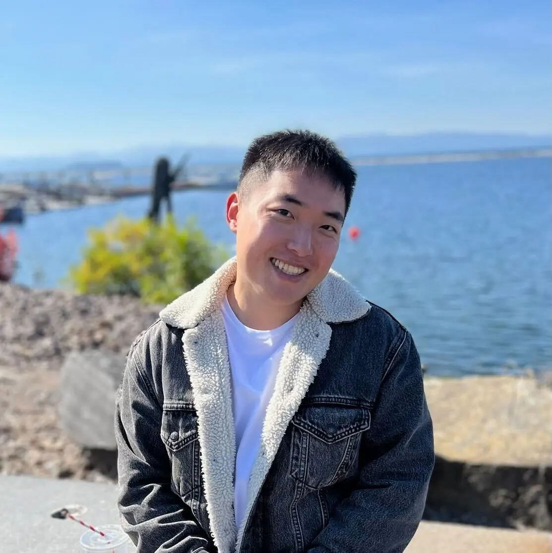 Will smiling by the water in a denim jacket