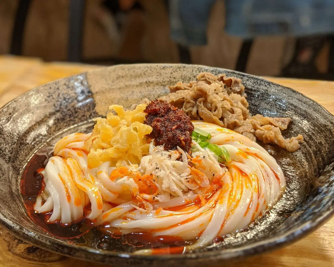 Bowl of thick udon noodles with chili oil and ground meat